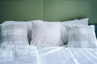 a white bed with pillows on top of it at Chic Preston Luxe Suite - Perfect for 2 - Free Parking by Parydise Properties in Grimsargh