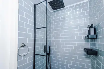 a bathroom with a shower with blue tiles at Chic Preston Luxe Suite - Perfect for 2 - Free Parking by Parydise Properties in Grimsargh
