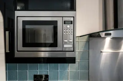 a microwave oven in a kitchen with blue tiles at Cemeas House - Air Host & Stay - Slps 6 - Parking in Liverpool