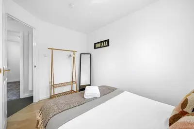 a bedroom with a white bed and a sign on the wall at Cemeas House - Air Host & Stay - Slps 6 - Parking in Liverpool