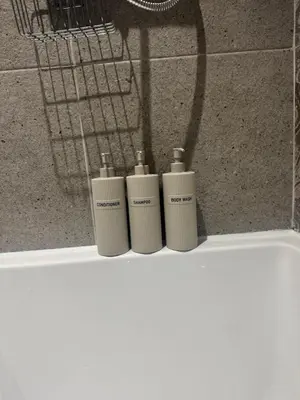 a group of three soap bottles sitting on top of a counter at Cozy bungalow in Standish