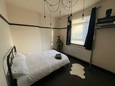 a bedroom with a white bed and a window at Reevell Avenue in Liverpool