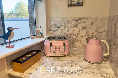 a kitchen counter with a pink toaster and a window at Driftwood Bay in Fleetwood