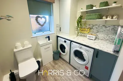 a small bathroom with a washer and dryer at Driftwood Bay in Fleetwood