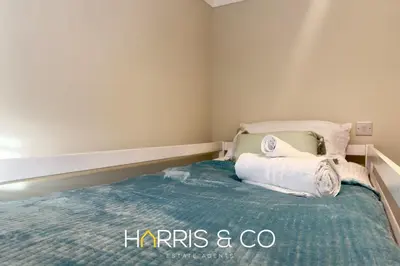 a small bedroom with a bed with towels on it at Driftwood Bay in Fleetwood