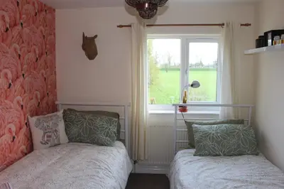 a bedroom with two beds and a window at Hornby Cottage in Saint Michaels on Wyre
