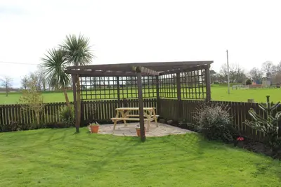 a wooden gazebo with a picnic table in a yard at Hornby Cottage in Saint Michaels on Wyre