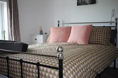 a bed with pink pillows on top of it at Hornby Cottage in Saint Michaels on Wyre