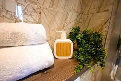 a bottle of soap on a table next to towels at Starr Place in Liverpool