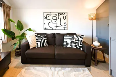 a living room with a brown couch with black and white pillows at Starr Place in Liverpool
