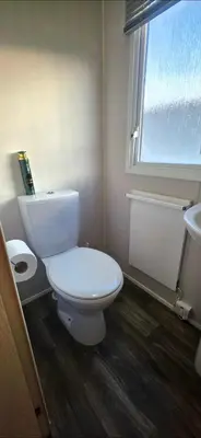 a bathroom with a white toilet and a sink at Vanhalla in Heysham