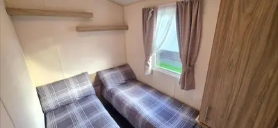 a room with a bed and a window with a couch at Vanhalla in Heysham