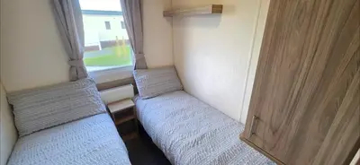 two beds in a small room with a window at Vanhalla in Heysham
