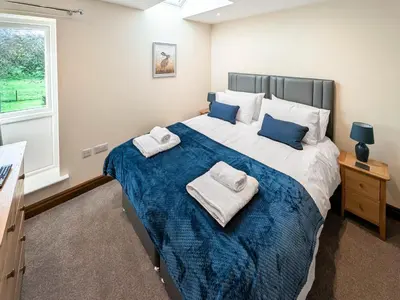 a bedroom with a large bed with towels on it at Bay Bungalow in Bolton le Sands