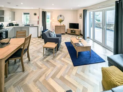 a living room with a dining table and a kitchen at Bay Bungalow in Bolton le Sands