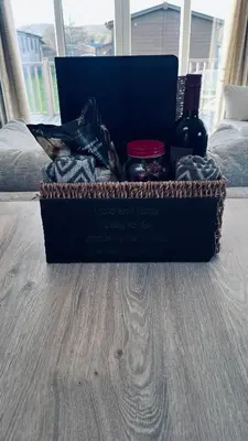 a gift box with a bottle of wine on a bed at Blue Water Retreats in Carnforth