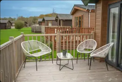 three chairs and a table on a deck at Blue Water Retreats in Carnforth