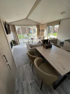 a living room with a wooden table and chairs at Blue Water Retreats in Carnforth
