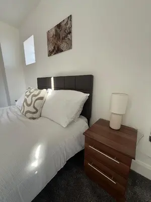 a bedroom with a bed and a nightstand with a lamp at Southport Coastal View Retreat in Southport