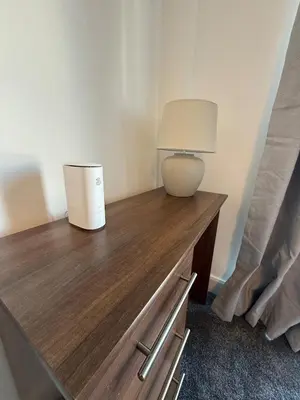 a bedroom with a wooden table with a lamp on it at Southport Coastal View Retreat in Southport