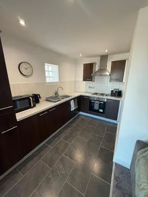 a kitchen with brown cabinets and a clock on the wall at Southport Coastal View Retreat in Southport