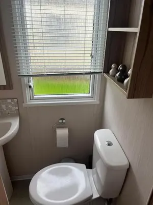 a small bathroom with a toilet and a window at S & S Retreat in Heysham