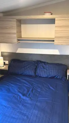 a bed with a blue comforter in a bedroom at S & S Retreat in Heysham