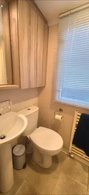 a bathroom with a white toilet and a sink at S & S Retreat in Heysham