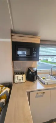 a kitchen with a microwave and a toaster on a counter at S & S Retreat in Heysham