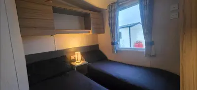 a small bedroom with a bed and a window at S & S Retreat in Heysham