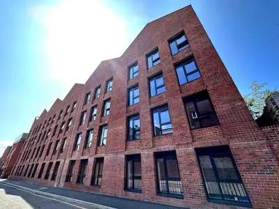 a red brick building with windows on a street at Modern Apartment Liverpool City Centre in Liverpool