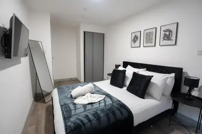 a bedroom with a large white bed with black and white pillows at Modern Apartment Liverpool City Centre in Liverpool