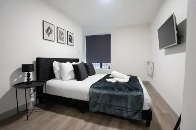 a bedroom with a bed with a table and a television at Modern Apartment Liverpool City Centre in Liverpool