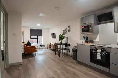 a kitchen and living room with a table and chairs at Modern Apartment Liverpool City Centre in Liverpool