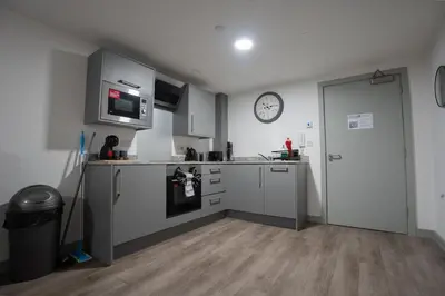 a kitchen with a clock on the wall and a door at Modern Apartment Liverpool City Centre in Liverpool