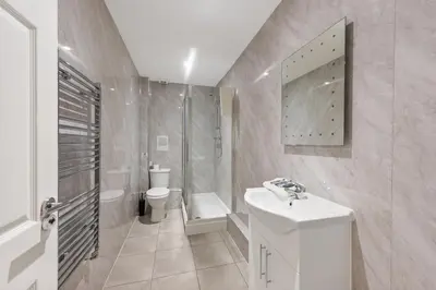 a white bathroom with a sink and a toilet at The Slater Pad - Party Apartment in Liverpool City Centre in Liverpool