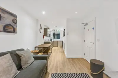 a living room with a couch and a kitchen at The Slater Pad - Party Apartment in Liverpool City Centre in Liverpool