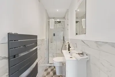 a white bathroom with a sink and a toilet at The Slater Pad - Party Apartment in Liverpool City Centre in Liverpool