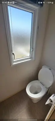a bathroom with a white toilet and a window at Joy & Mick's Happy Place in Morecambe