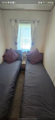 two beds in a room with a window at Joy & Mick's Happy Place in Morecambe