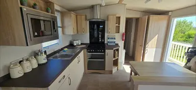a kitchen with a sink and a stove top oven at Joy & Mick's Happy Place in Morecambe