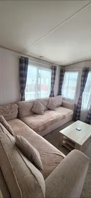 a living room with a large couch and a table at Joy & Mick's Happy Place in Morecambe