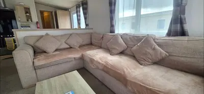 a brown couch in a living room with a window at Joy & Mick's Happy Place in Morecambe