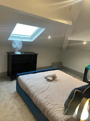a bedroom with a large bed with a skylight at Station View Apartments in Blackpool
