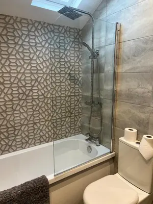 a bathroom with a shower and a toilet and a tub at Station View Apartments in Blackpool