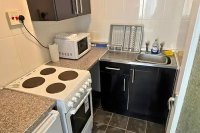 a small kitchen with a stove and a microwave at 1 Bedroom apartment by Brookland Stays Serviced Accommodation & Short Lets in Blackpool in Blackpool