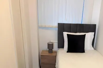 a bed with a black headboard and a pillow on a table at 1 Bedroom apartment by Brookland Stays Serviced Accommodation & Short Lets in Blackpool in Blackpool