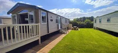 a mobile home with a porch and a deck at Lakeland Holiday Home in Flookburgh