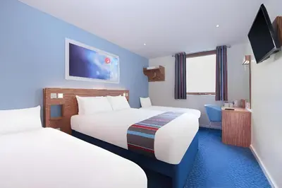 a hotel room with two beds and a tv at Travelodge Liverpool Central Exchange Street in Liverpool