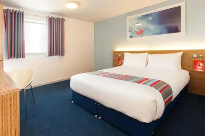 a hotel room with a large bed and a desk at Travelodge Liverpool Central Exchange Street in Liverpool